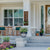 beautiful front porch with seating area of two chairs and table with brown modern house number entry envy sign with Irish st. Patrick's day decor kit