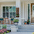 beautiful front porch with seating area of two chairs and table with brown modern house number entry envy sign with Irish st. Patrick's day decor kit