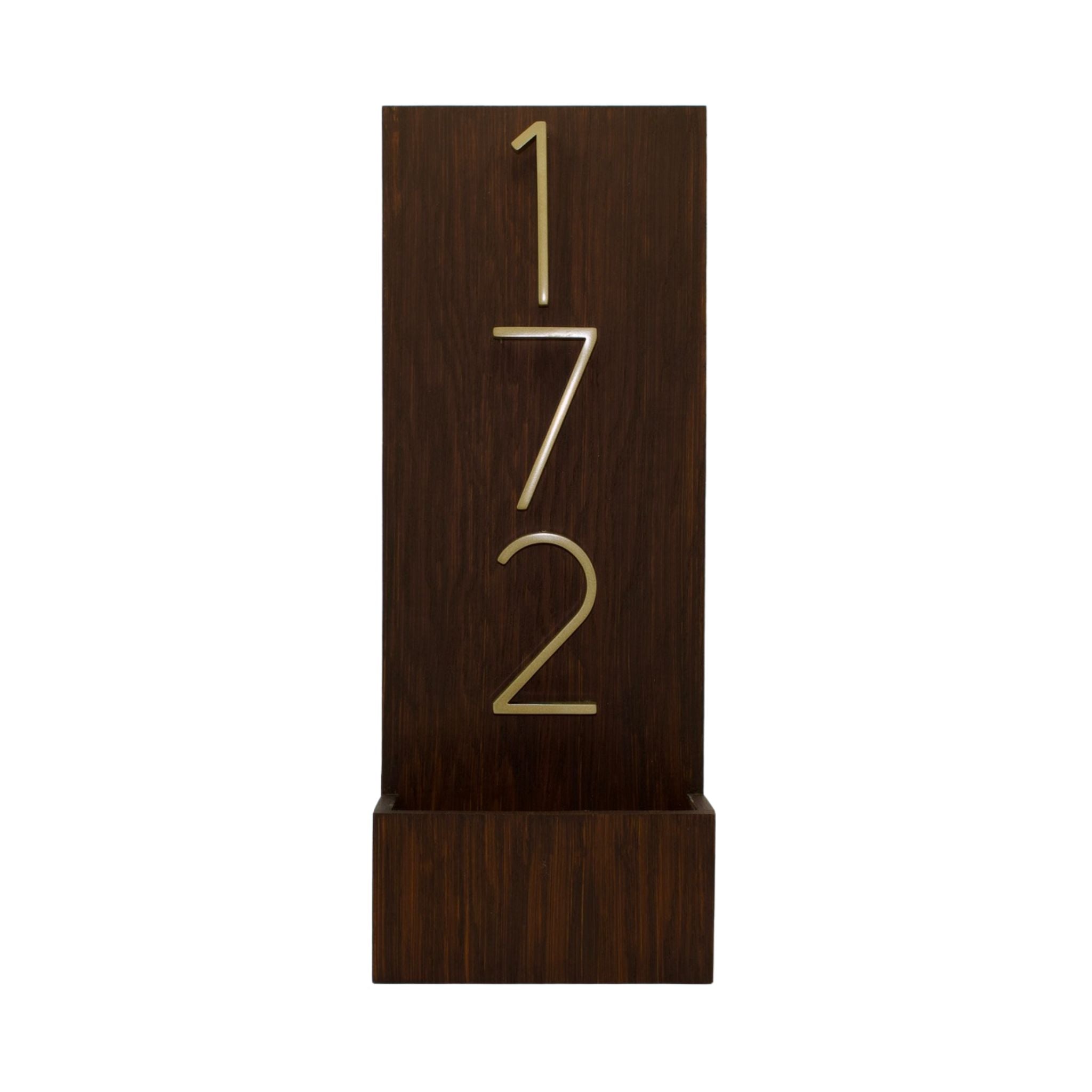 Brown wooden vertical house number sign featuring raised modern gold numbers 172.
