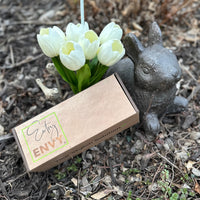 Image of box with gift card inside next to white tulips and bunny statue  Edit alt text